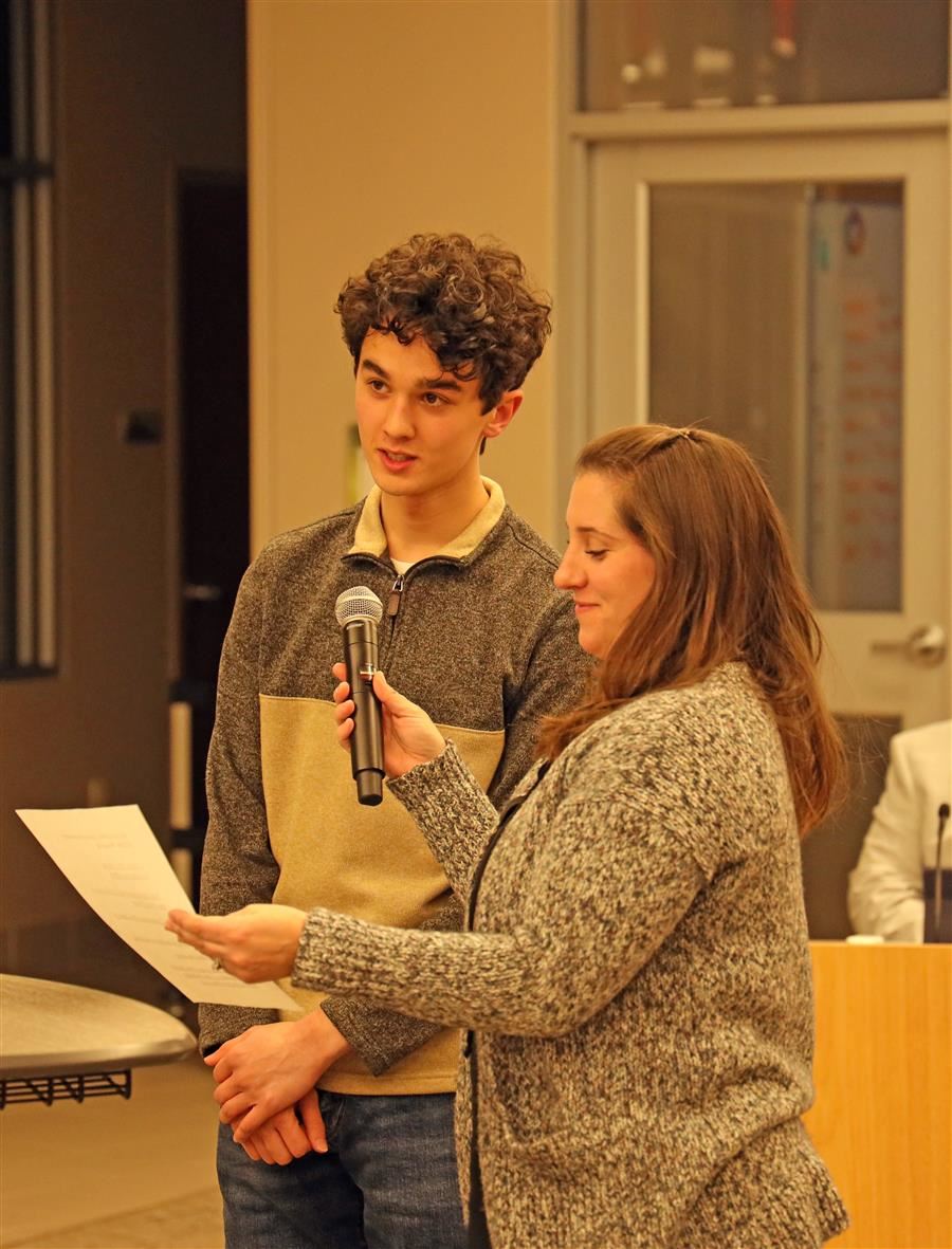  New student representative RJ is introducted by board member Megan Vedder, who is handing him a mic